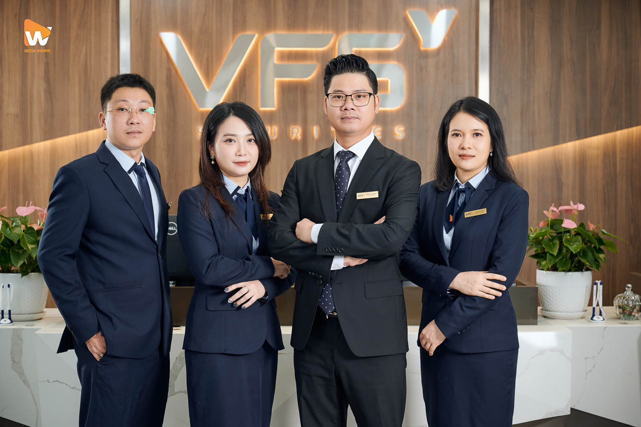 Nhóm 4 nhân sự VFS Securities đứng trước logo tại quầy giao dịch